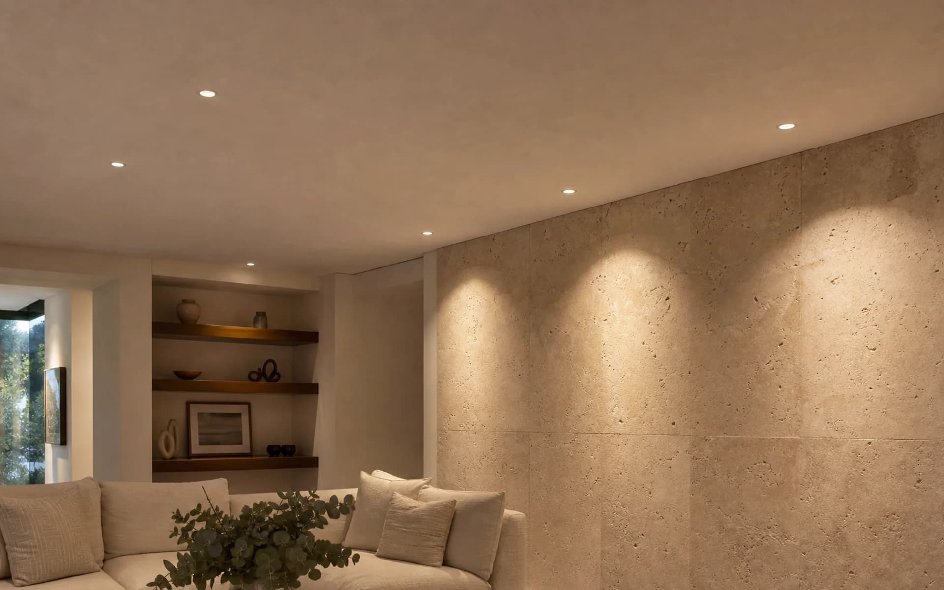 Residential limestone wall and ceiling illuminated by warm recessed downlights