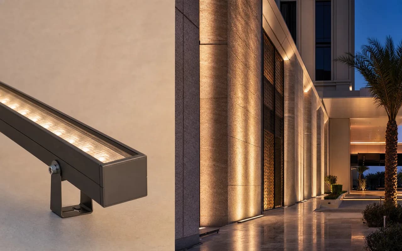 Slim linear wall-washing luminaire beside an illustrative warm facade-lighting concept